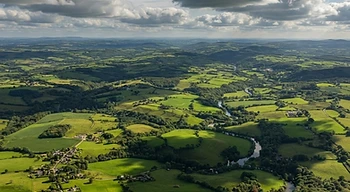 Clouds casting shadows across a sunlit landscape.