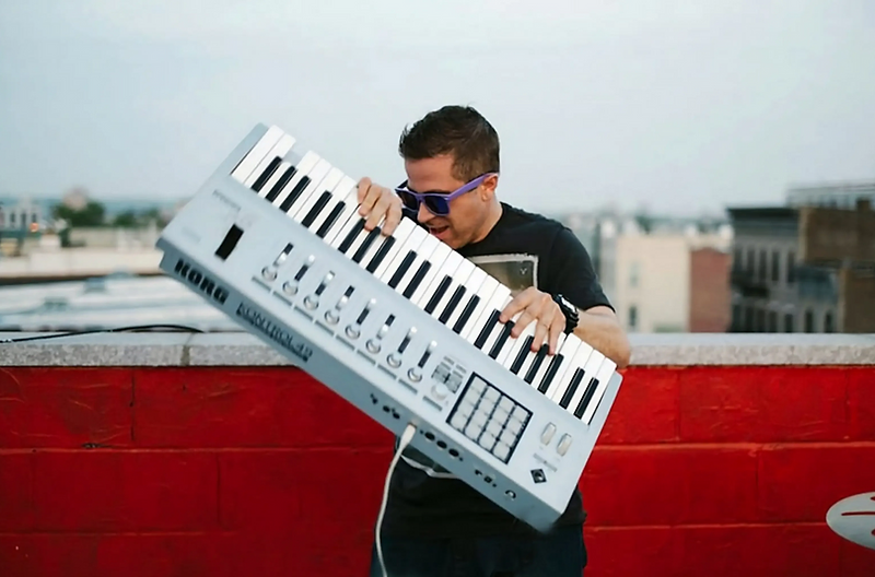 Chris Strange performing on a rooftop with a keytar