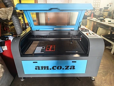 KEVMAR's CO₂ laser machine with the lid open, showing the honeycomb cutting bed and laser gantry system.