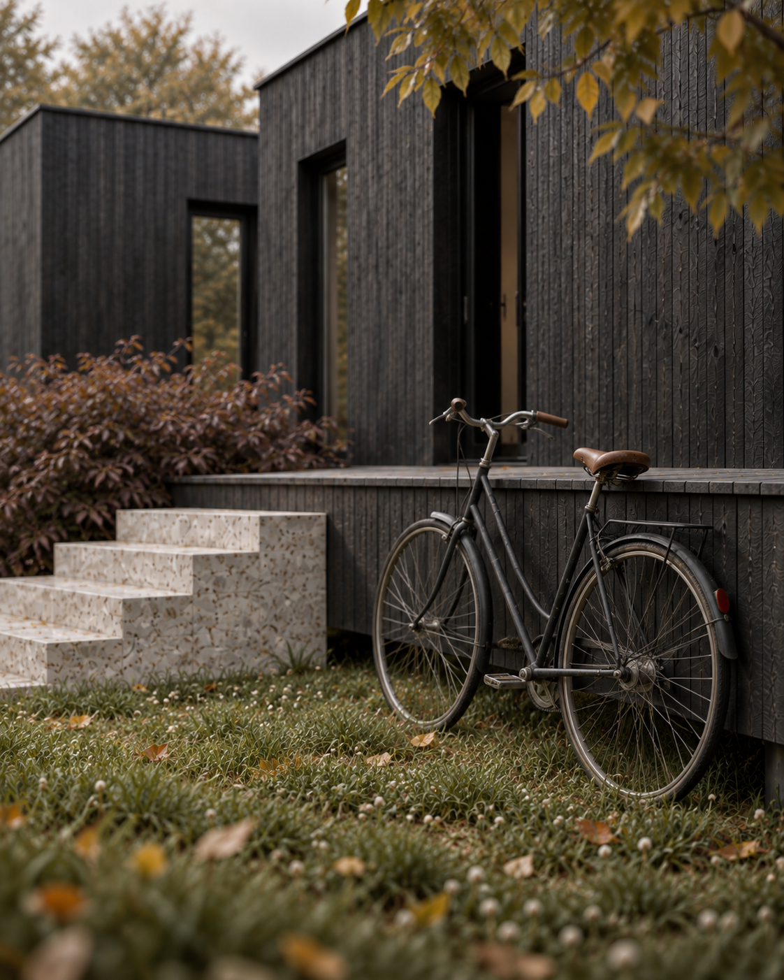 Maison en bois brûlé, escaliers en terrazzo et vélo vintage