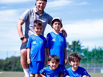 Trainer mit vier Nachwuchsspielern auf dem Platz