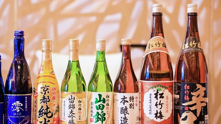 The interior of a professional exhibition hall at the CCEC with wine exhibitors meeting with trade visitors, featuring clear signage and sophisticated booth displays.