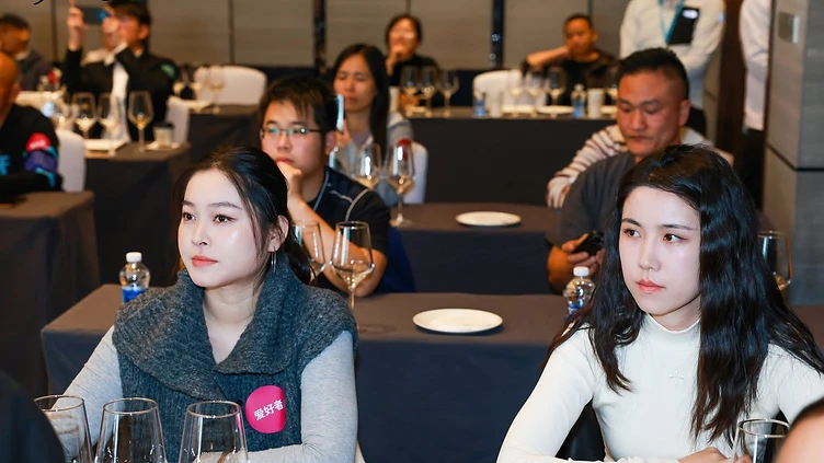 Wine trade professionals and regional distributors discussing imported wine samples at a Southwest China commercial exhibition