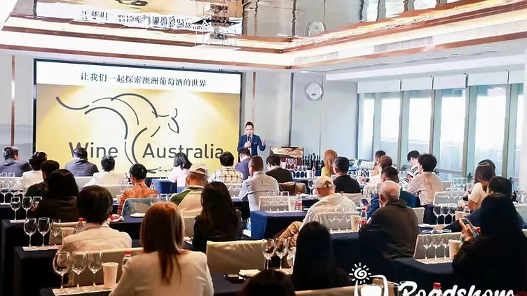 Spirits brand managers and Asian beverage importers discussing distribution contracts and cocktail menu placement at a trade pavilion