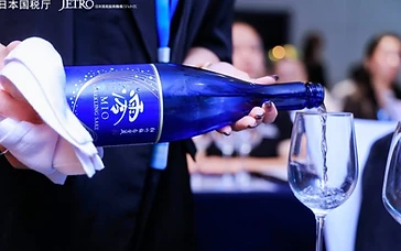 International wine exhibitors presenting bottles to professional buyers at the Interwine trade exhibition hall