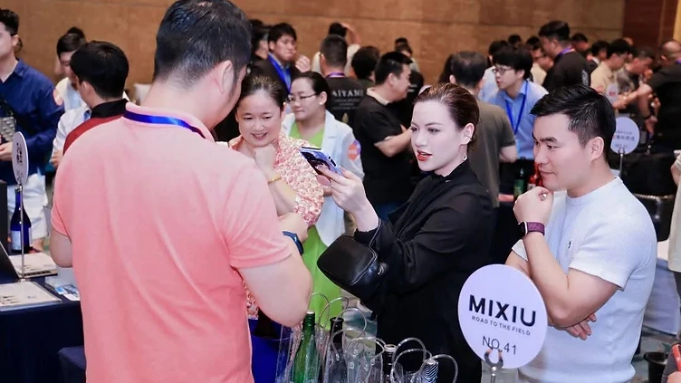 Professional wine buying team conducting a B2B tasting and negotiation at an international trade show booth