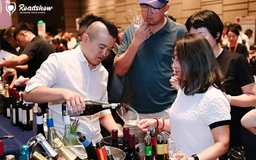 Wine export manager presenting portfolio and pricing sheets to Thai wine buyers during a B2B trade meeting