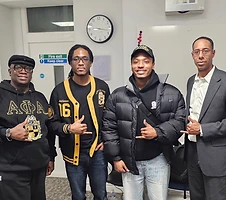 Brothers gathered in Alpha Phi Alpha apparel indoors