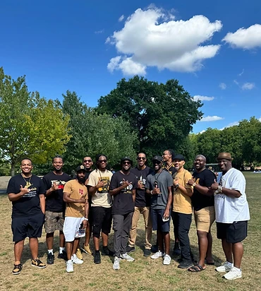 Brothers gathered outdoors in a London park on a sunny day
