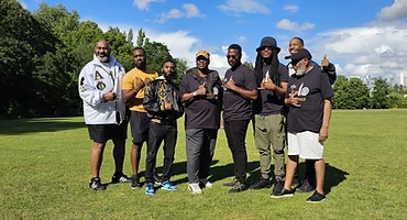 Brothers gathered outdoors in a London park wearing chapter apparel