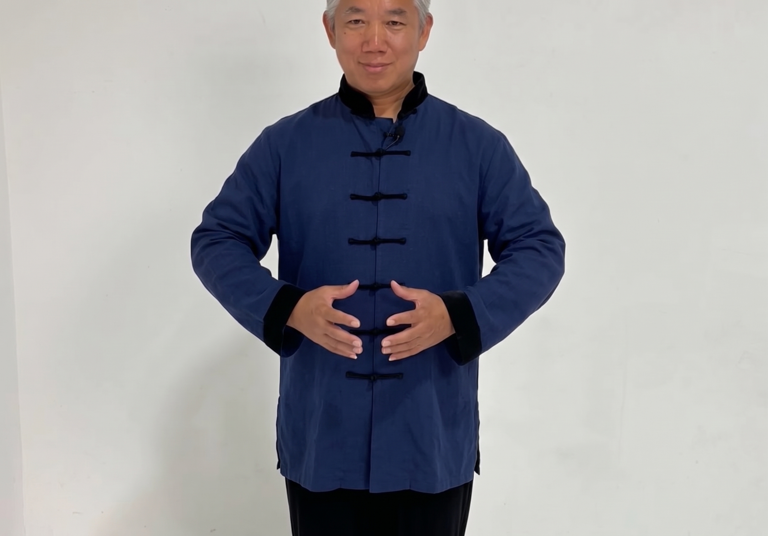 A person practising the La Qi open-and-absorb Qigong gesture at dawn