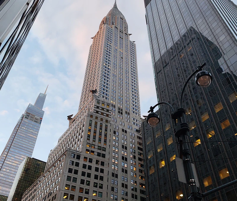 Upward view of the Chrysler Building and Midtown Manhattan towers at dusk