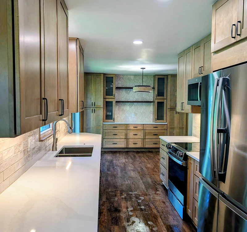 Newly remodeled galley kitchen with custom wood cabinetry, stone-mosaic feature wall and floating shelves in Hartville, Ohio