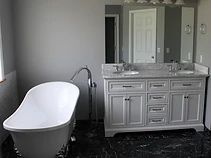 Remodeled primary bathroom with freestanding tub, double vanity and marble finishes in Hartville, Ohio