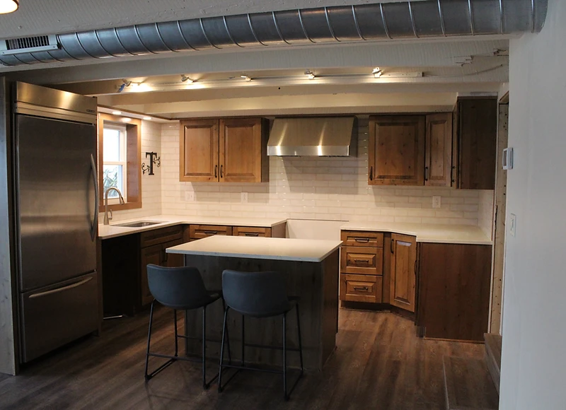 Finished kitchen remodel with custom cabinetry, island and pendant lighting