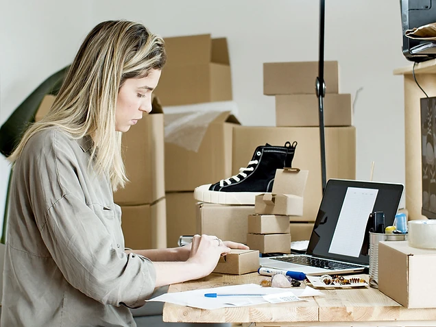 E-commerce fulfillment — packing orders at a small business desk