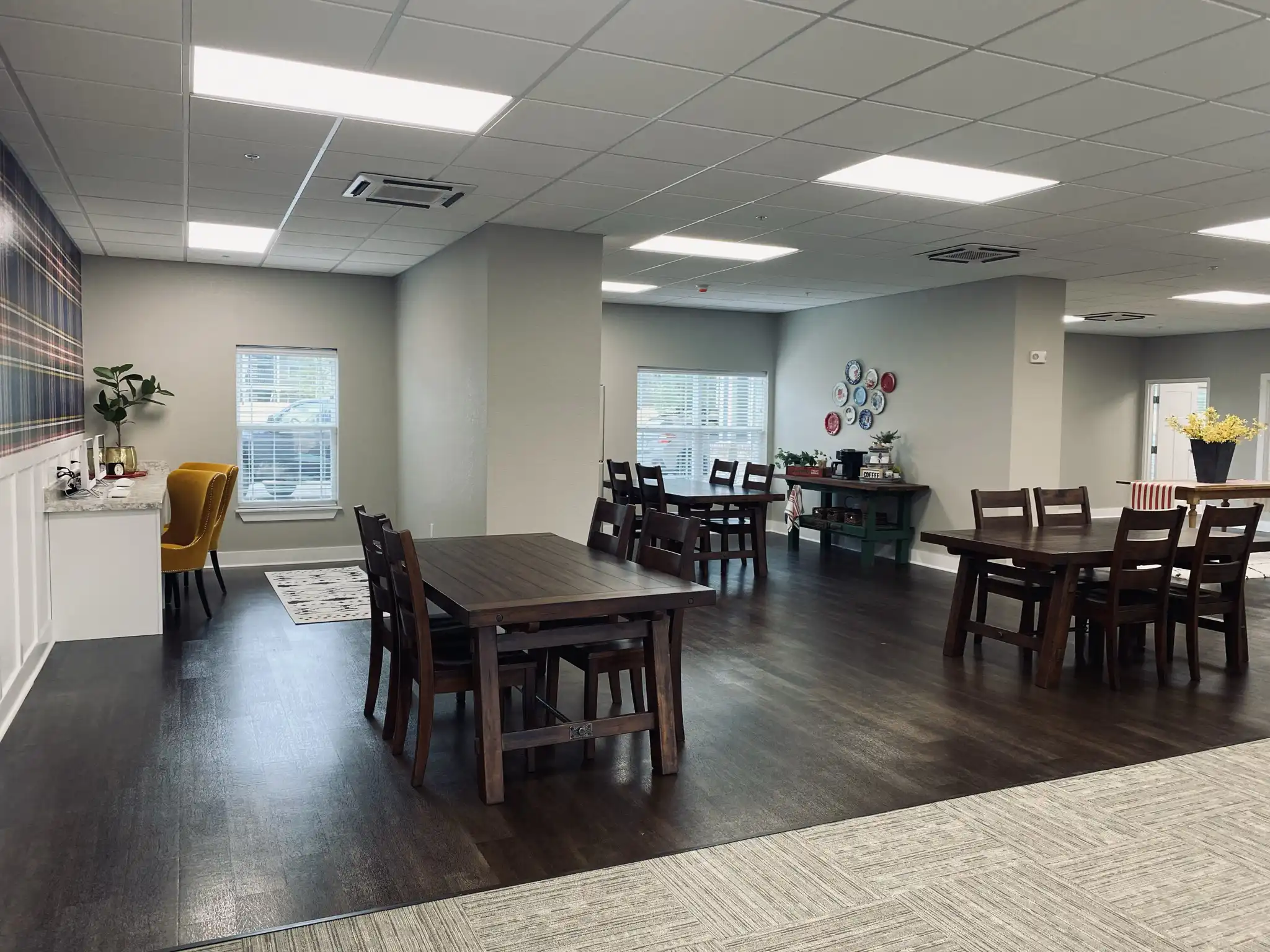 Community room with dining tables, seating area, and natural light at a Trinity Housing Development property