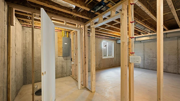 Basement interior with exposed wood framing and concrete walls