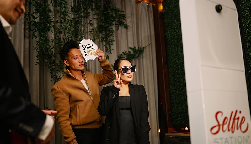 Guests posing at a Selfie Station photo booth