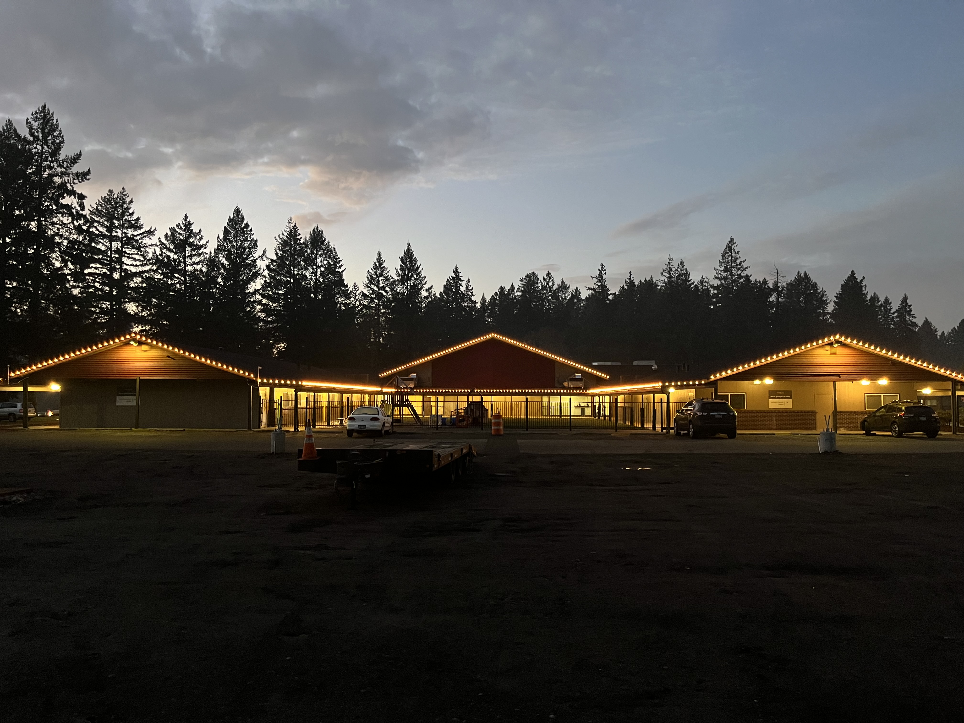 Building with warm C9 lighting across three gabled rooflines at dusk