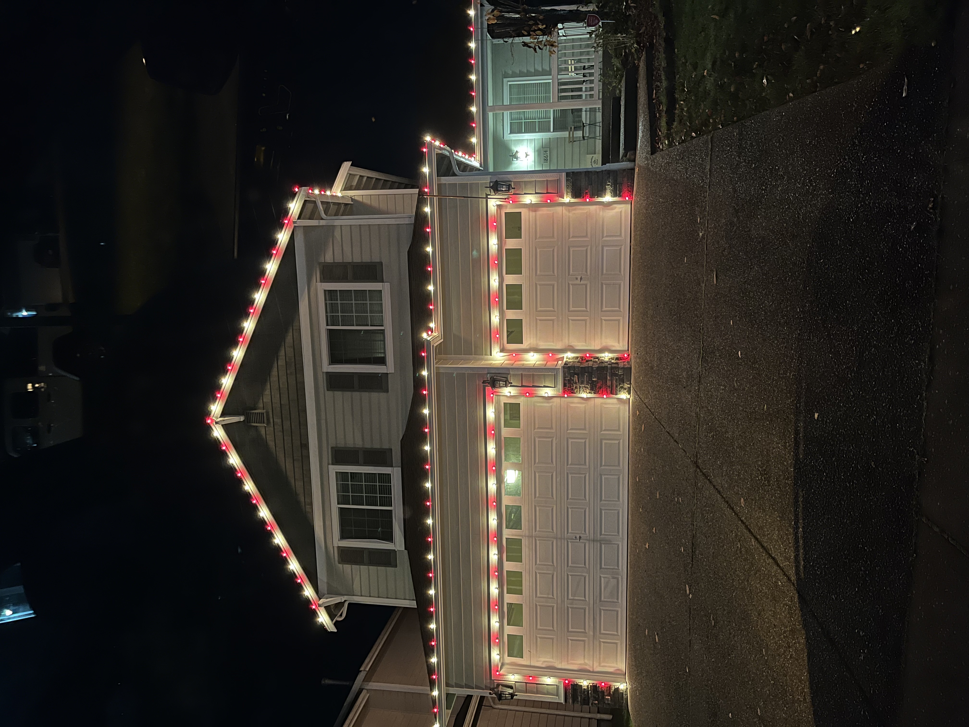 Two-story home with warm white and red C9 roofline lighting