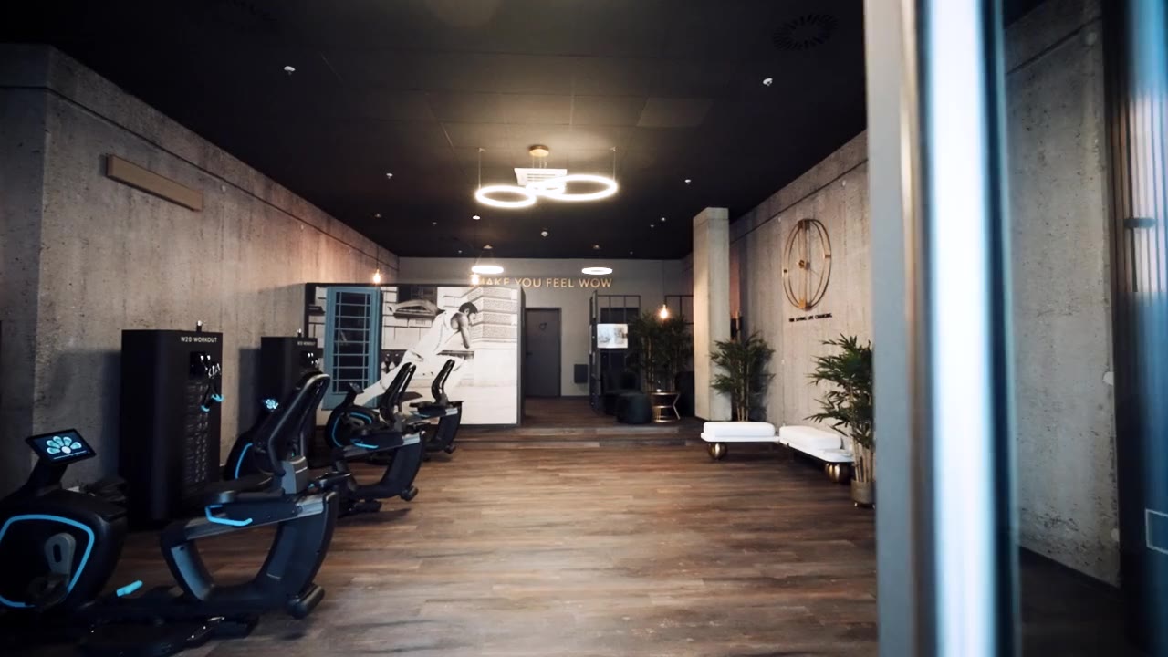 W20 Workout Heidelberg: Innenraum des Studios mit Trainingsgeräten und der Leuchtschrift Make You Feel Wow