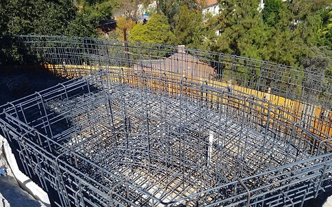 Aerial view of a pool rebar grid with vertical perimeter steel and wooden formwork before shotcrete