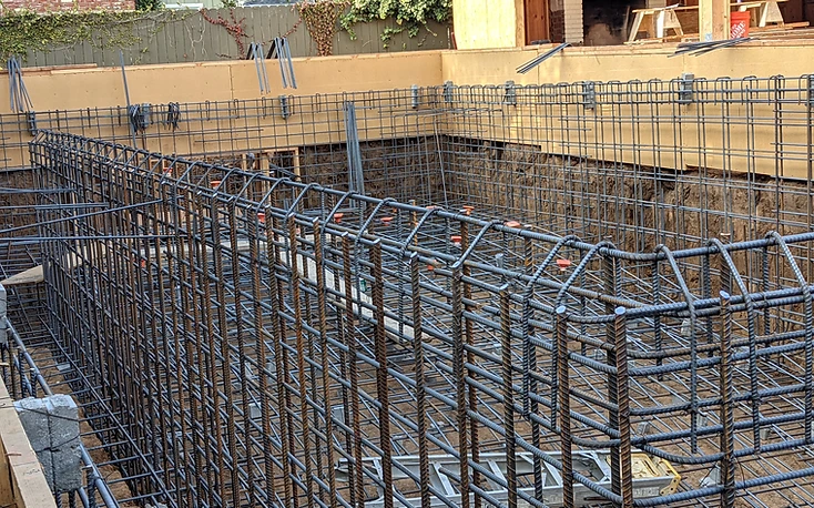 Double-layer rebar wall assembly meeting wooden formwork in a pool corner