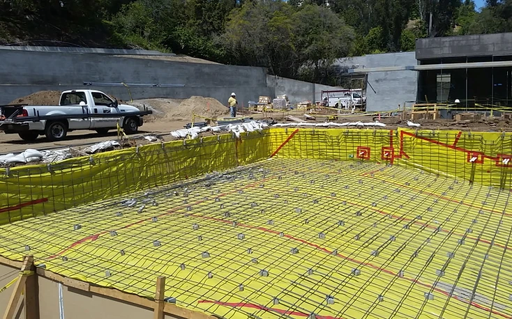 Rectangular pool excavation with waterproofing membrane and a reinforcing steel grid laid over it