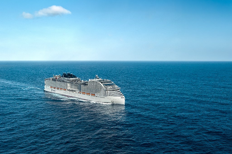 A large white-hulled MSC cruise ship sailing through deep blue open ocean