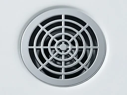 Macro shot of a polished chrome drain opening with geometric metal grating