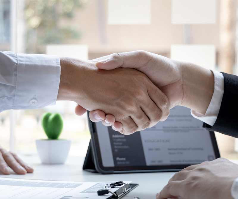 Professionals shaking hands across a desk