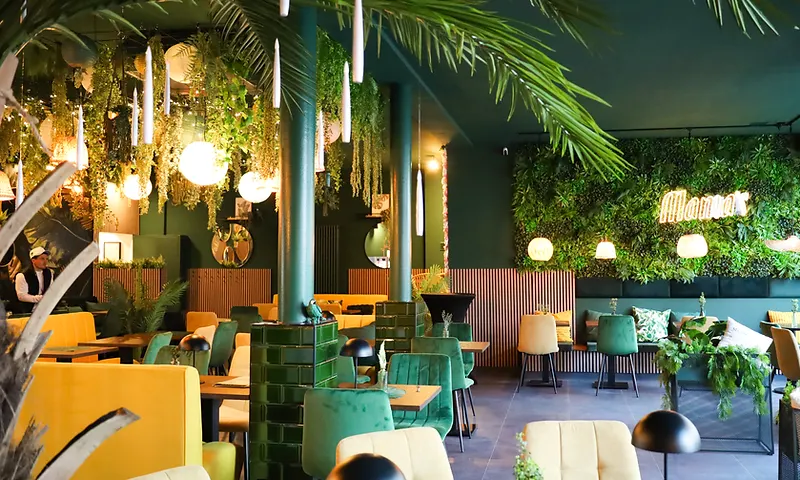 Mama's Café Interior mit grüner Pflanzen- und Neon-Leuchtschrift