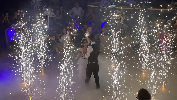 Bruid en bruidegom dansen de openingsdans omringd door cold sparks