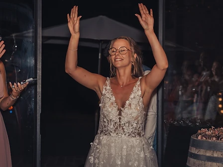 Bruid geniet van het feest met beide handen in de lucht