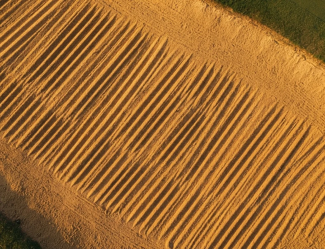 Raked sand bunker ripples forming a geometric pattern