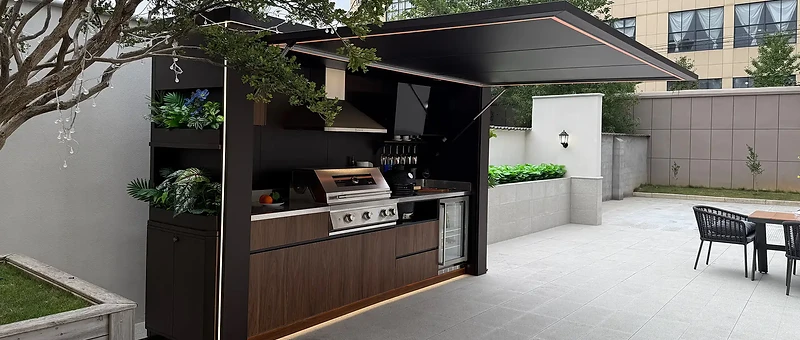 Modern outdoor kitchen unit on a tiled patio under a cantilevered awning