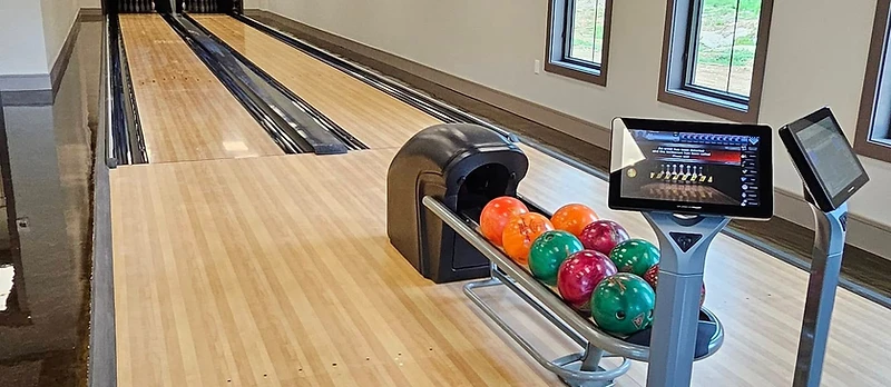Custom venue barn interior with bar and bowling lane by Backyard and Barns