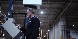An operator at the robot's control panel