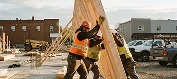 Construction crew raising a stud wall on a small commercial build in Oromocto.