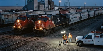 Rail yard with locomotives and freight cars at a prairie rail divisional point at dusk