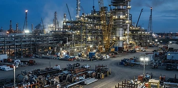Petrochemical construction site with cranes and pipe fabrication yard in Fort Saskatchewan at dusk