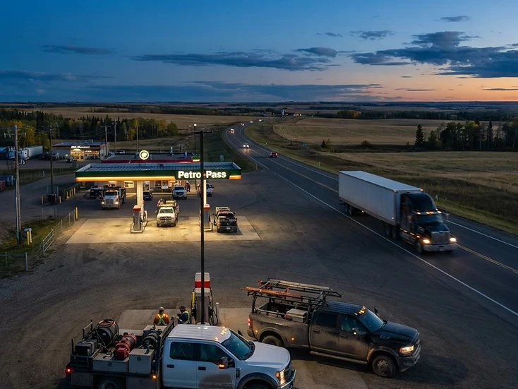 Oilfield service trucks and farm equipment on Highway 43 farmland near Valleyview, Alberta