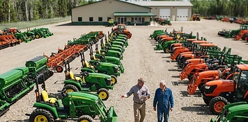 A farmer and dealer walking between rows of new tractors at a bright Parkland equipment yard