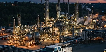 Petroleum refinery complex on Edmonton's industrial east side with a maintenance truck at dusk