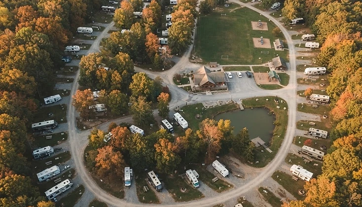 Aerial overhead view of a wooded campground and RV park