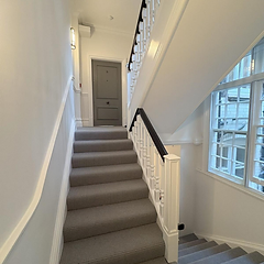 Staircase with freshly painted white balusters and handrail