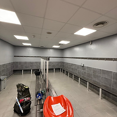Staff changing room with slatted benches and tiled walls