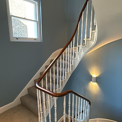 Curved staircase in slate blue with white balusters and new stair carpet