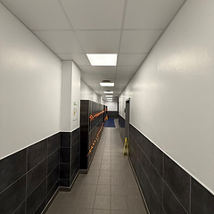 Commercial changing room corridor with charcoal tiles and new lockers
